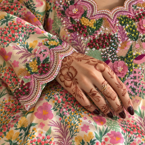 Close-up of the Bloom scalloped cuff, beaded with pink flowers and pearl-look edging