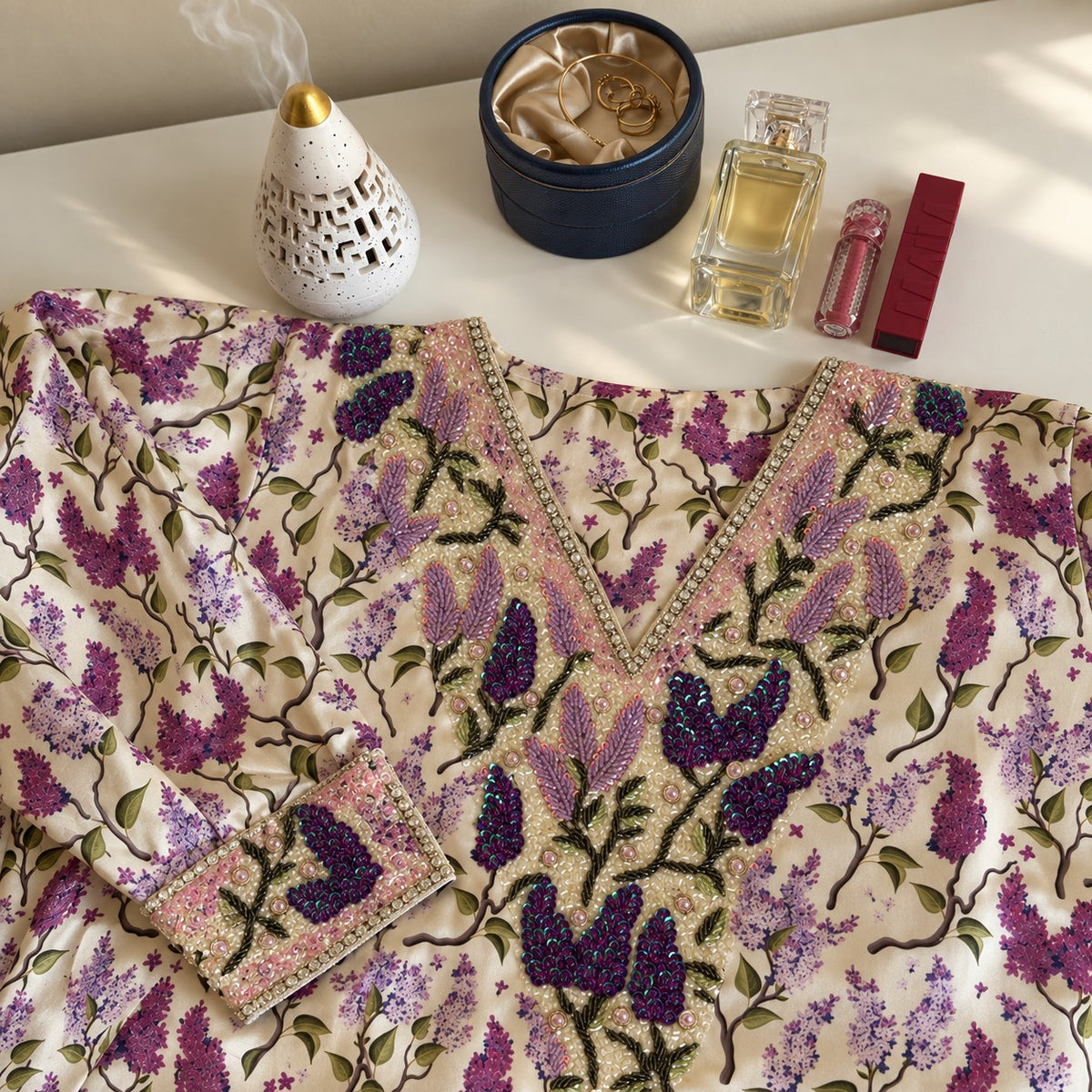 Lilac laid flat, showing the ivory lilac-branch print and sequinned lilac V-neckline