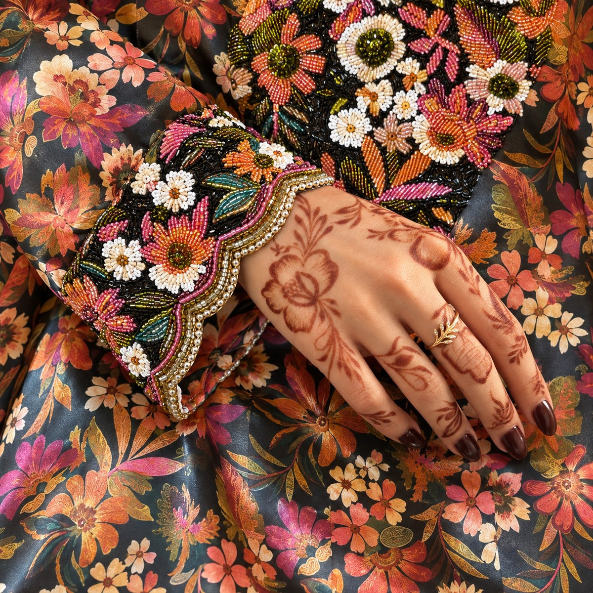 Close-up of the Oud scalloped cuff with beaded daisies and coral blooms
