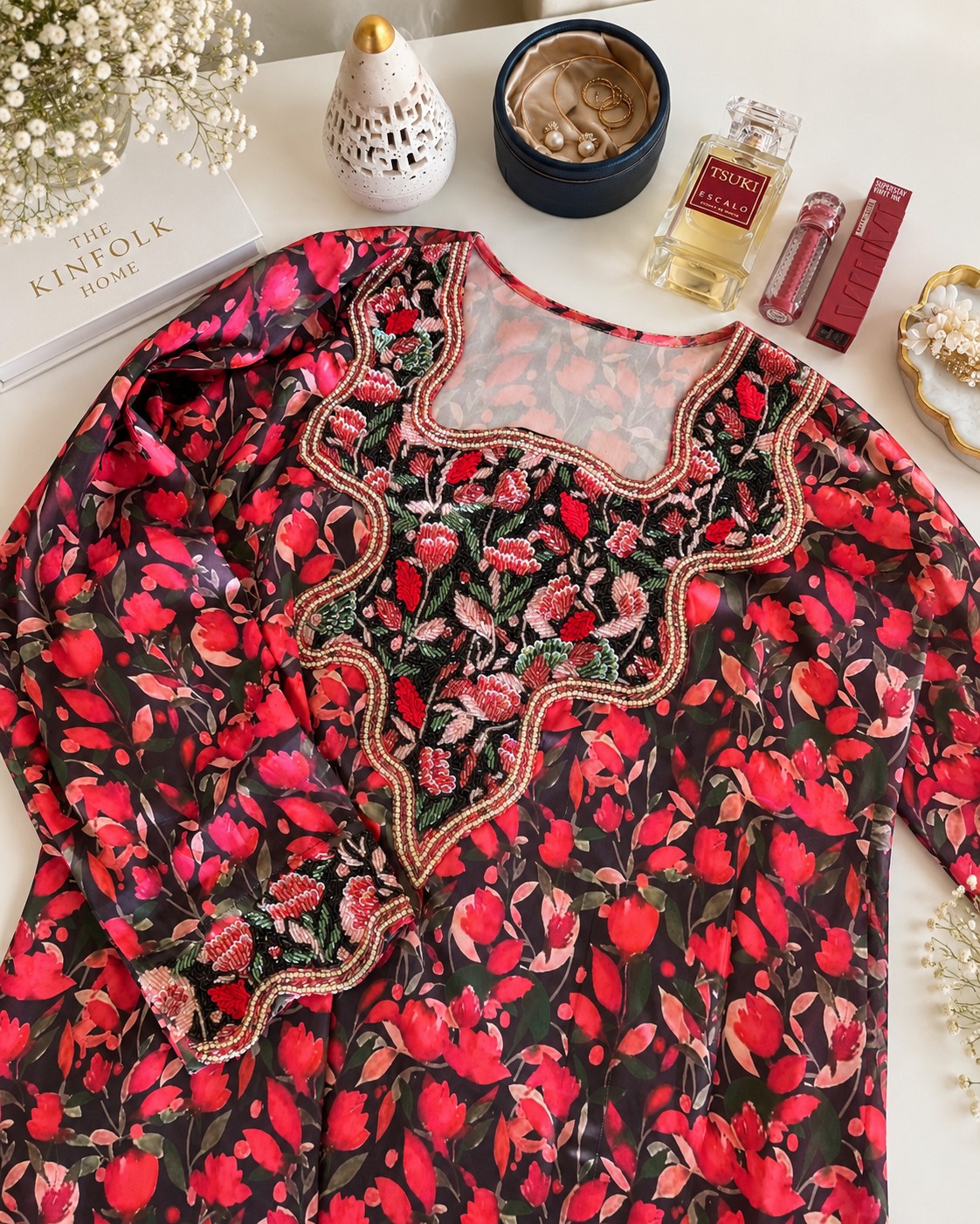 Zafran laid flat, showing the black tulip print and scalloped neckline with beaded roses